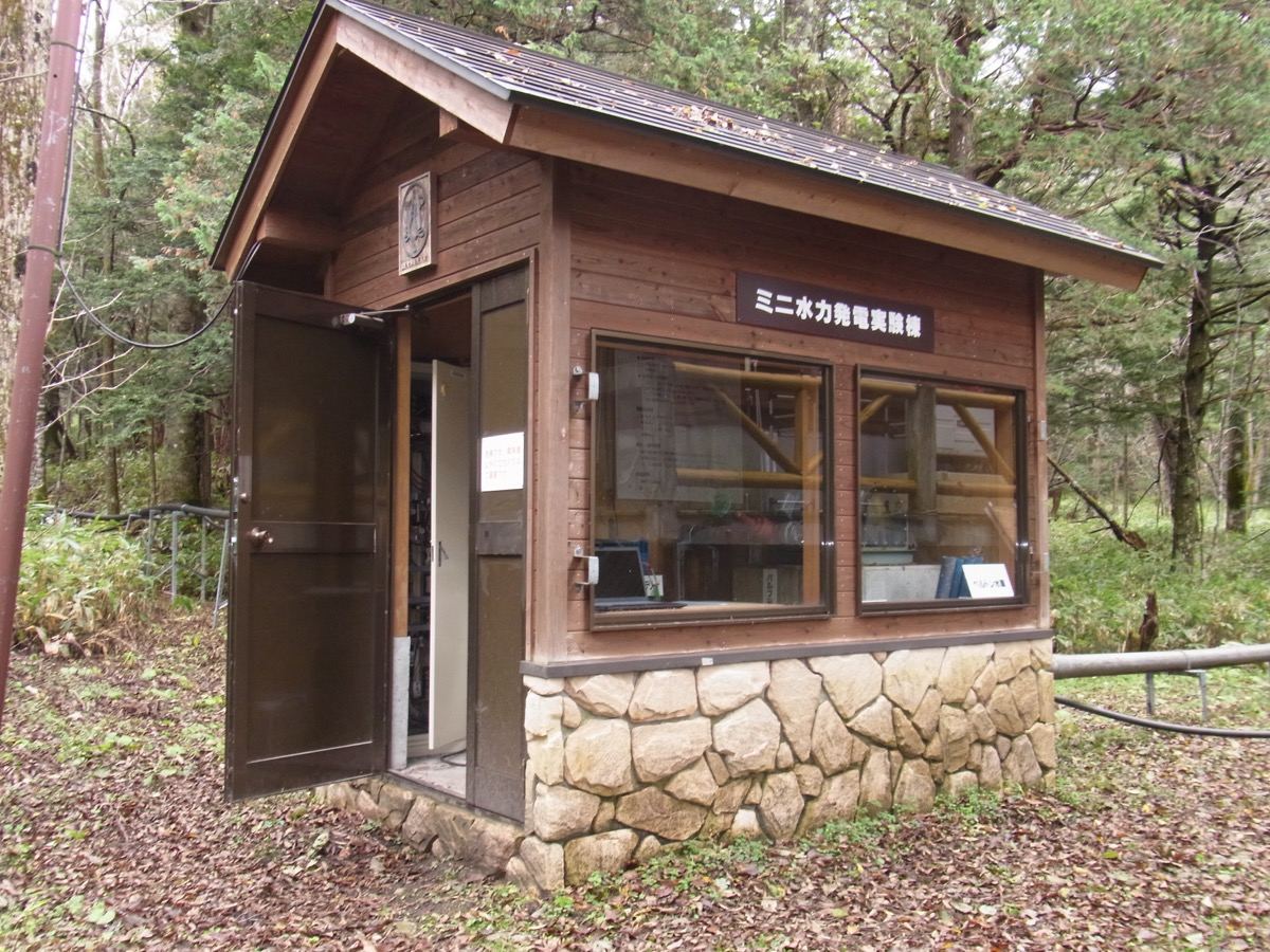 森の中に建つ木造の「ミニ水力発電実験棟」